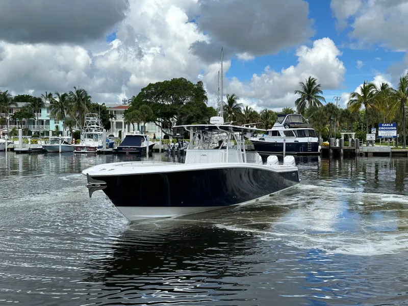 Slide: The Image of 2013 Invincible 42 Open Fisherman boat cruising in a scenic marina. - 2