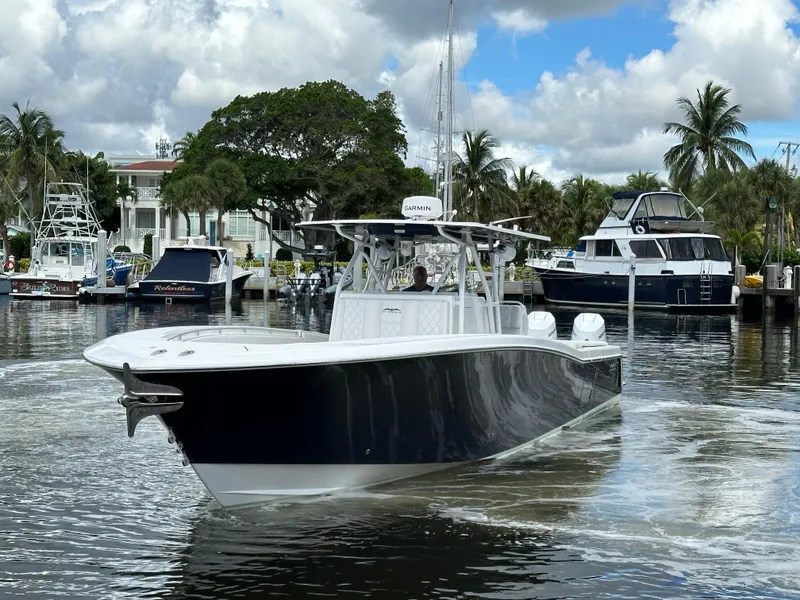 Slide: The Image of 2013 Invincible 42 Open Fisherman boat on a calm marina with palm trees. - 3