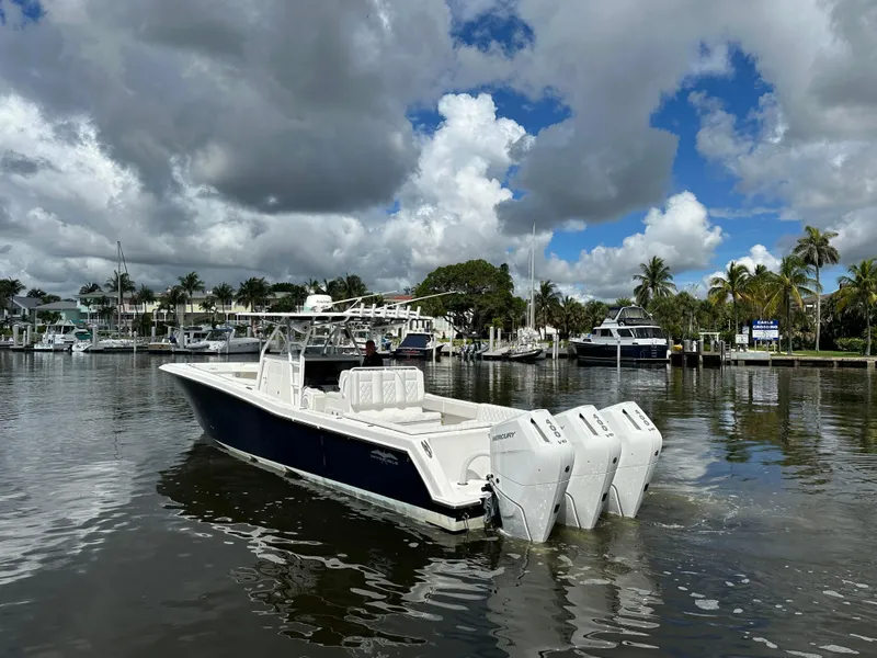 Slide: The Image of 2013 Invincible 42 Open Fisherman boat docked on a calm, scenic waterfront. - 5