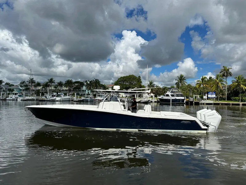Slide: The Image of 2013 Invincible 42 Open Fisherman boat on calm water, cloudy sky background. - 6