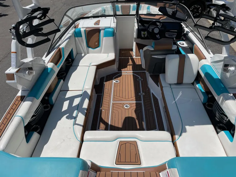 Slide: The Image of 2017 Nautique Super Air G23 boat interior with white, brown, and turquoise seating. - 5