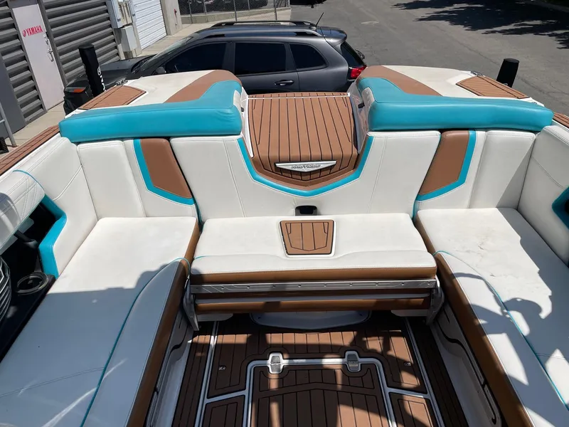 Slide: The Image of 2017 Nautique Super Air G23 boat interior with white, brown, and turquoise seating. - 8