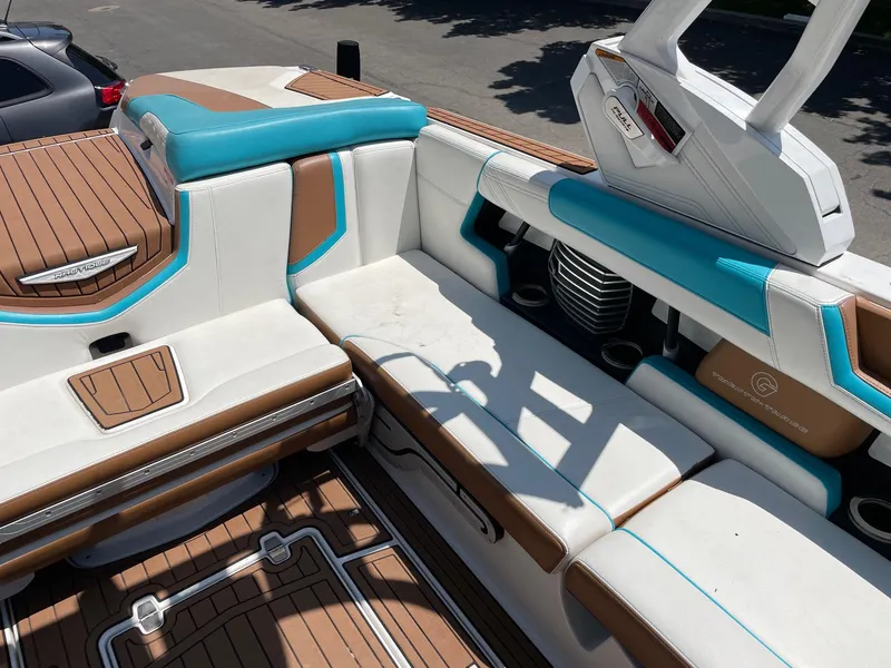 Slide: The Image of 2017 Nautique Super Air G23 boat interior with white, brown, and blue seating. - 9
