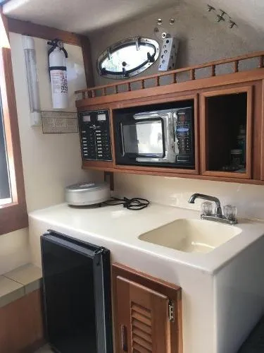 Slide: The Image of 2000 Albemarle 280 Express Fisherman boat interior with kitchenette, sink, and microwave. - 27