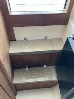 Slide: The Image of Interior steps of 2000 Albemarle 280 Express Fisherman boat, featuring wooden and metal details. - 40