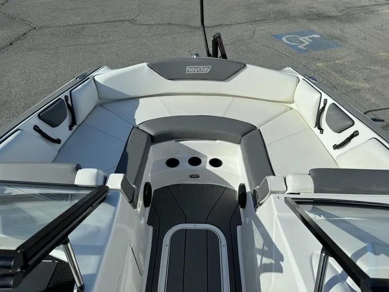 Slide: The Image of 2021 Heyday WT-2 boat interior with white and gray seating, docked on pavement. - 26