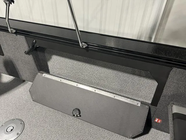 Slide: The Image of 2025 Lund 2075 Fisherman Sport interior with storage compartment and carpeted flooring. - 11