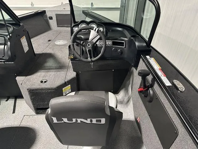 Slide: The Image of Interior of 2025 Lund 2075 Fisherman Sport boat, featuring steering wheel and seating. - 13