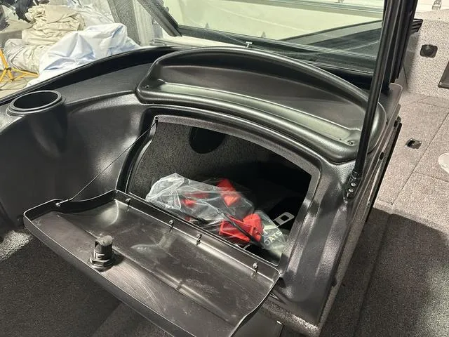 Slide: The Image of 2025 Lund 2075 Fisherman Sport boat storage compartment with open hatch and gear inside. - 20