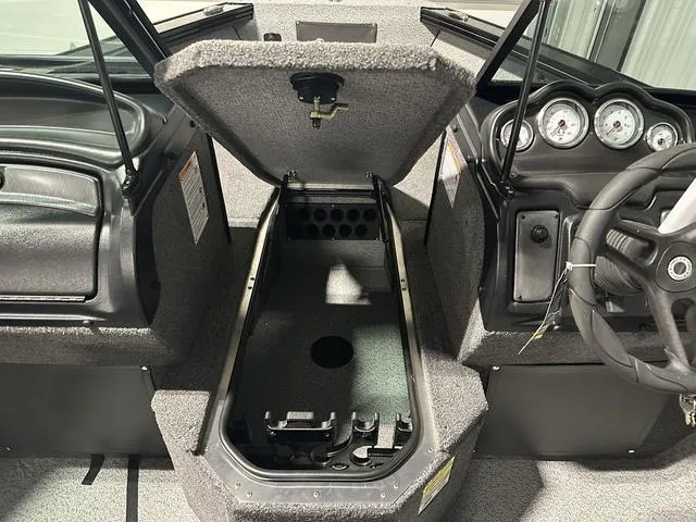 Slide: The Image of 2025 Lund 2075 Fisherman Sport boat interior with open storage compartment and dashboard. - 21