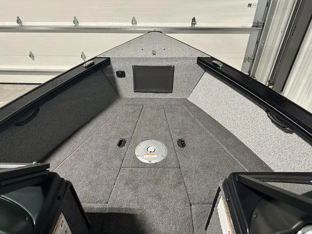 Slide: The Image of 2025 Lund 2075 Fisherman Sport boat interior with gray carpet and storage compartments. - 24