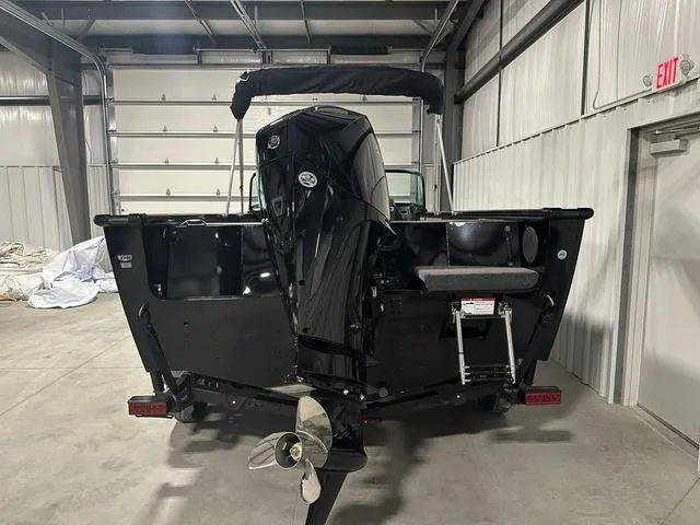 Slide: The Image of 2025 Lund 2075 Fisherman Sport boat in a garage, rear view with outboard motor. - 5