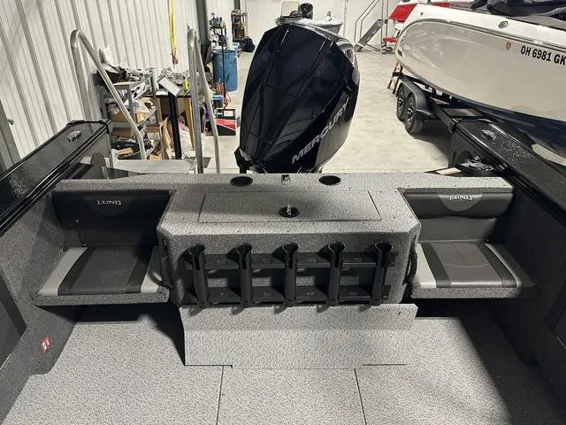 Slide: The Image of 2025 Lund 2075 Fisherman Sport boat interior with Mercury engine in a garage. - 8