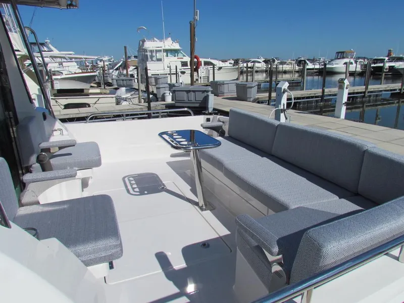 Slide: The Image of 2025 Sabre 43 Salon Express yacht with spacious outdoor seating at marina. - 11