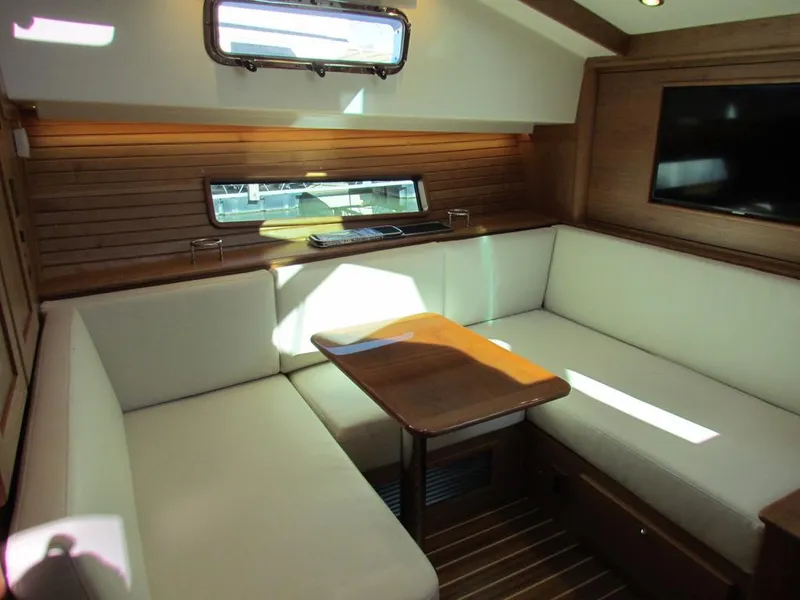 Slide: The Image of Interior of 2025 Sabre 43 Salon Express with cozy seating and wooden accents. - 2