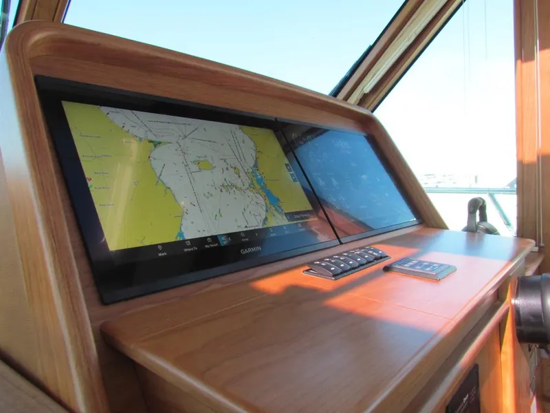 Slide: The Image of 2025 Sabre 43 Salon Express helm with navigation display and controls. - 25