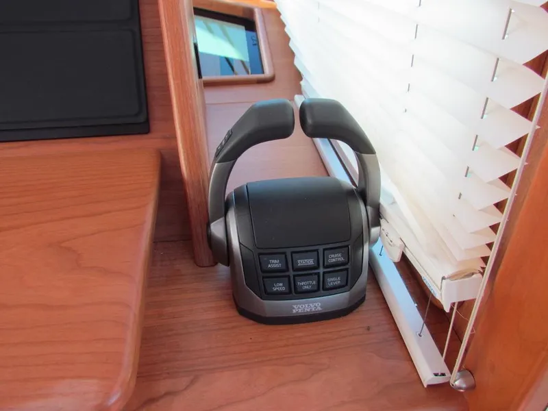 Slide: The Image of 2025 Sabre 43 Salon Express throttle control on wooden dashboard near window blinds. - 26