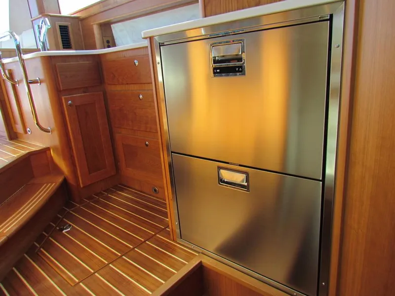 Slide: The Image of 2025 Sabre 43 Salon Express interior with stainless steel appliances and wooden cabinetry. - 31
