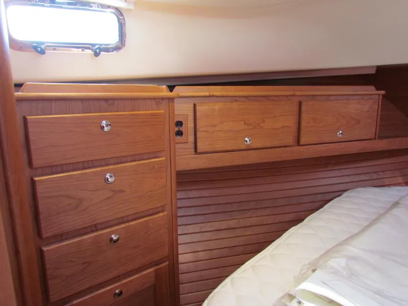 Slide: The Image of 2025 Sabre 43 Salon Express cabin with wooden drawers and bed. - 41