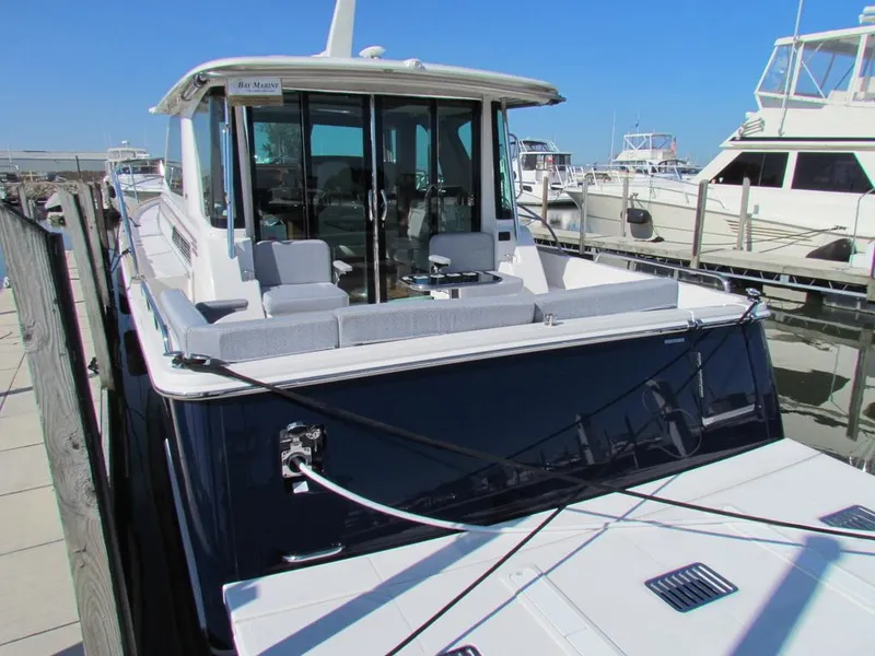 Slide: The Image of 2025 Sabre 43 Salon Express yacht docked at marina, featuring spacious outdoor seating. - 46