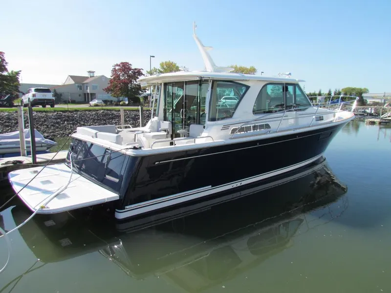 Slide: The Image of 2025 Sabre 43 Salon Express yacht docked in a serene marina setting. - 51