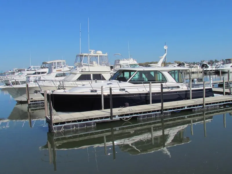 Slide: The Image of 2025 Sabre 43 Salon Express yacht docked in a marina under clear blue skies. - 53