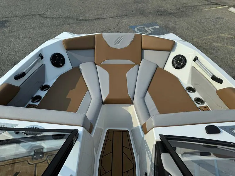 Slide: The Image of 2023 ATX Surf Boats 20 Type-S interior with brown and gray seating, cup holders, and speakers. - 13