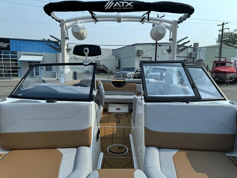 Slide: The Image of 2023 ATX Surf Boats 20 Type-S interior with tan and white seating, open windshield, and tower speakers. - 14