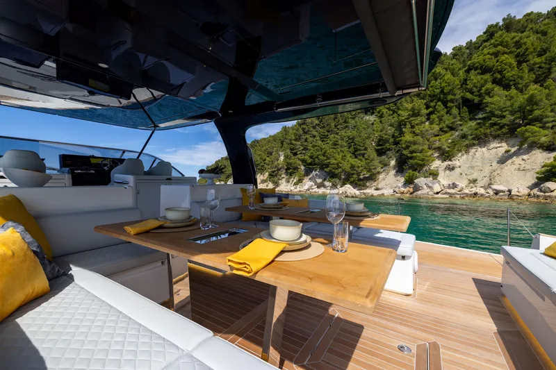 Slide: The Image of Luxurious 2025 Solaris Power 60 Open yacht with elegant dining area and scenic coastal view. - 11