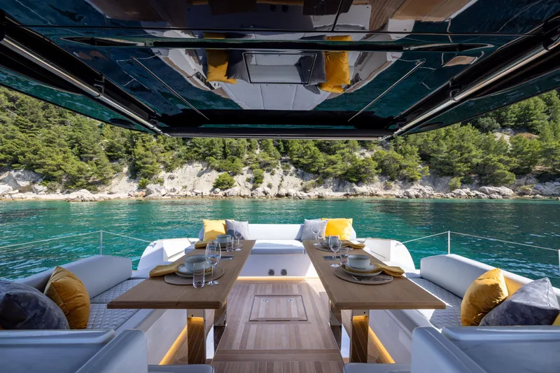 Slide: The Image of Luxurious 2025 Solaris Power 60 Open yacht with elegant dining setup, overlooking serene turquoise waters. - 13