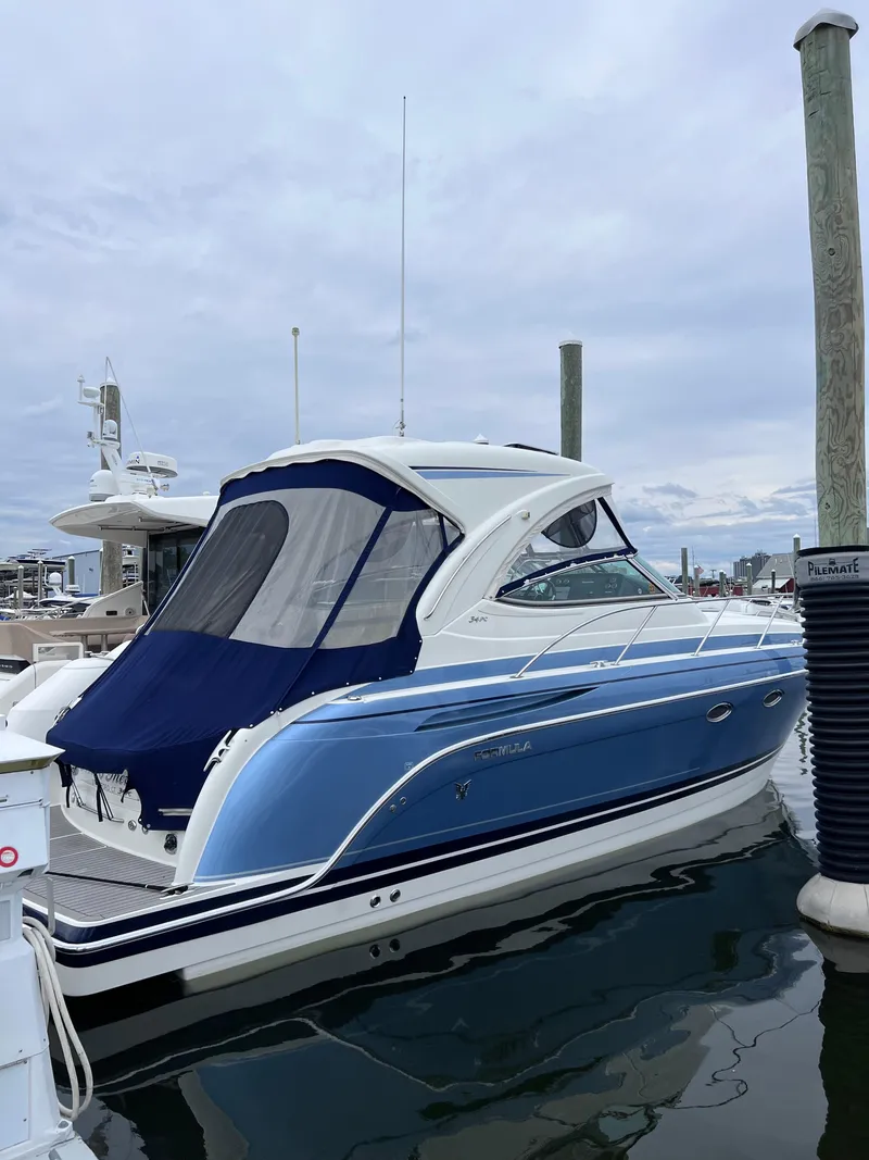 Slide: The Image of 2018 Formula 34 PC boat docked, featuring sleek blue and white design. - 10