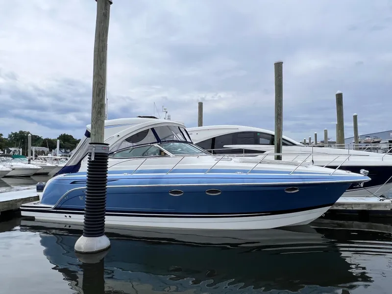 Slide: The Image of 2018 Formula 34 PC boat docked in marina, blue and white exterior. - 7