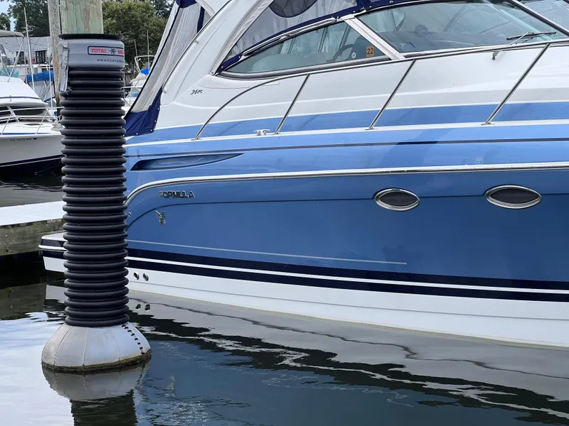 Slide: The Image of 2018 Formula 34 PC boat docked in marina, blue and white exterior. - 8