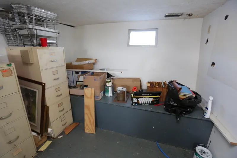 Slide: The Image of Storage room with filing cabinets, boxes, and miscellaneous items on a 1988 Winston Knauss 64 boat. - 16