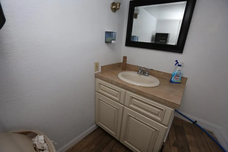 Slide: The Image of Small bathroom with sink and mirror on a 1988 Winston Knauss 64 party boat. - 23