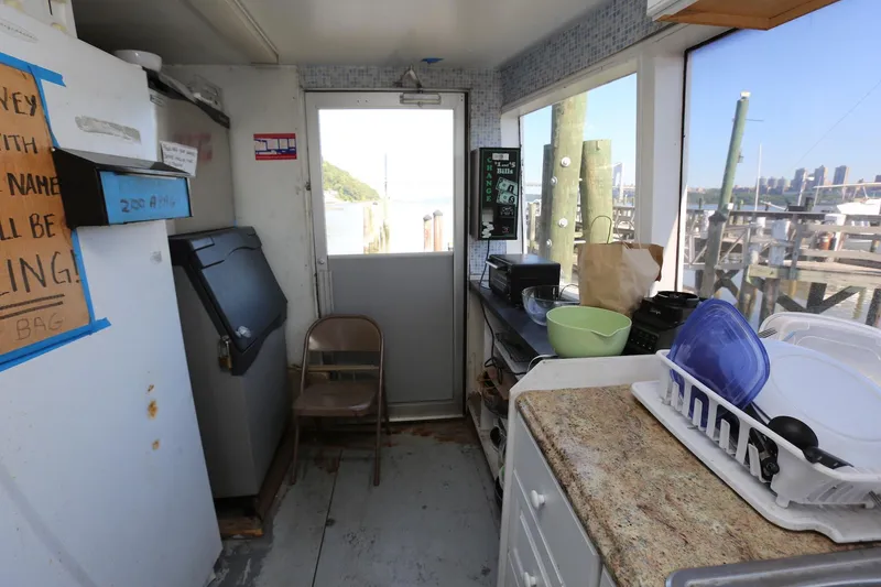 Slide: The Image of Interior of 1988 Winston Knauss 64 party boat kitchen area with appliances and dock view. - 29