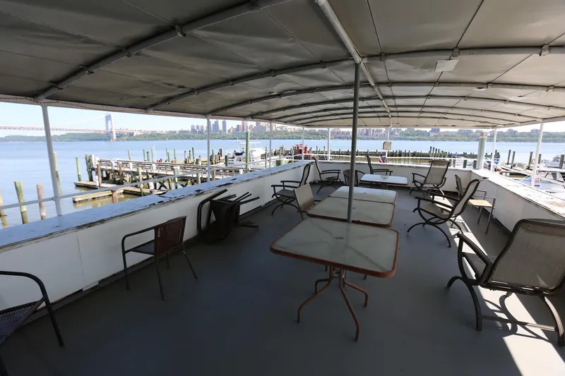 Slide: The Image of Covered deck of 1988 Winston Knauss 64 party boat with tables and chairs, overlooking waterfront. - 37
