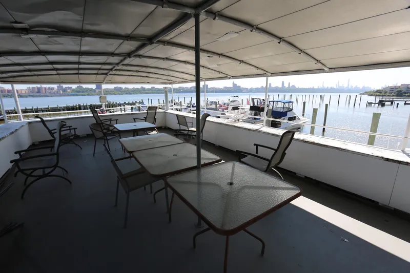 Slide: The Image of Covered deck of 1988 Winston Knauss 64 party boat with waterfront view. - 38