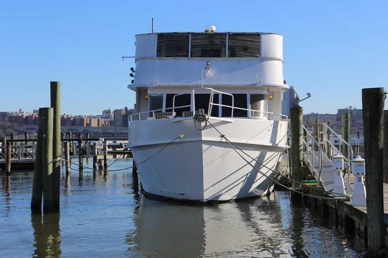 Slide: The Image of White Winston Knauss 64 party boat docked, 1988 model, clear blue sky background. - 6