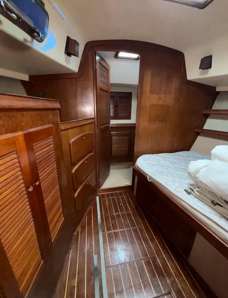 Slide: The Image of 1987 Island Packet 38 yacht interior with wooden cabinetry and cozy sleeping area. - 11