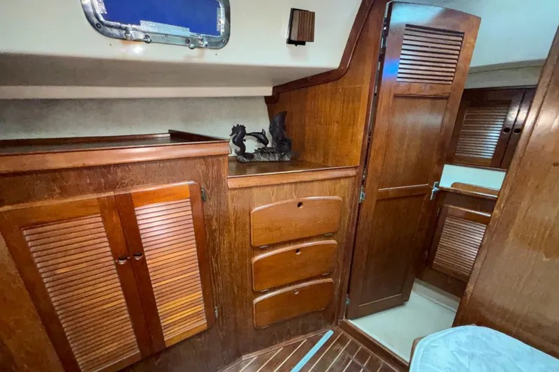 Slide: The Image of 1987 Island Packet 38 interior with wooden cabinets and drawers, showcasing nautical design. - 13
