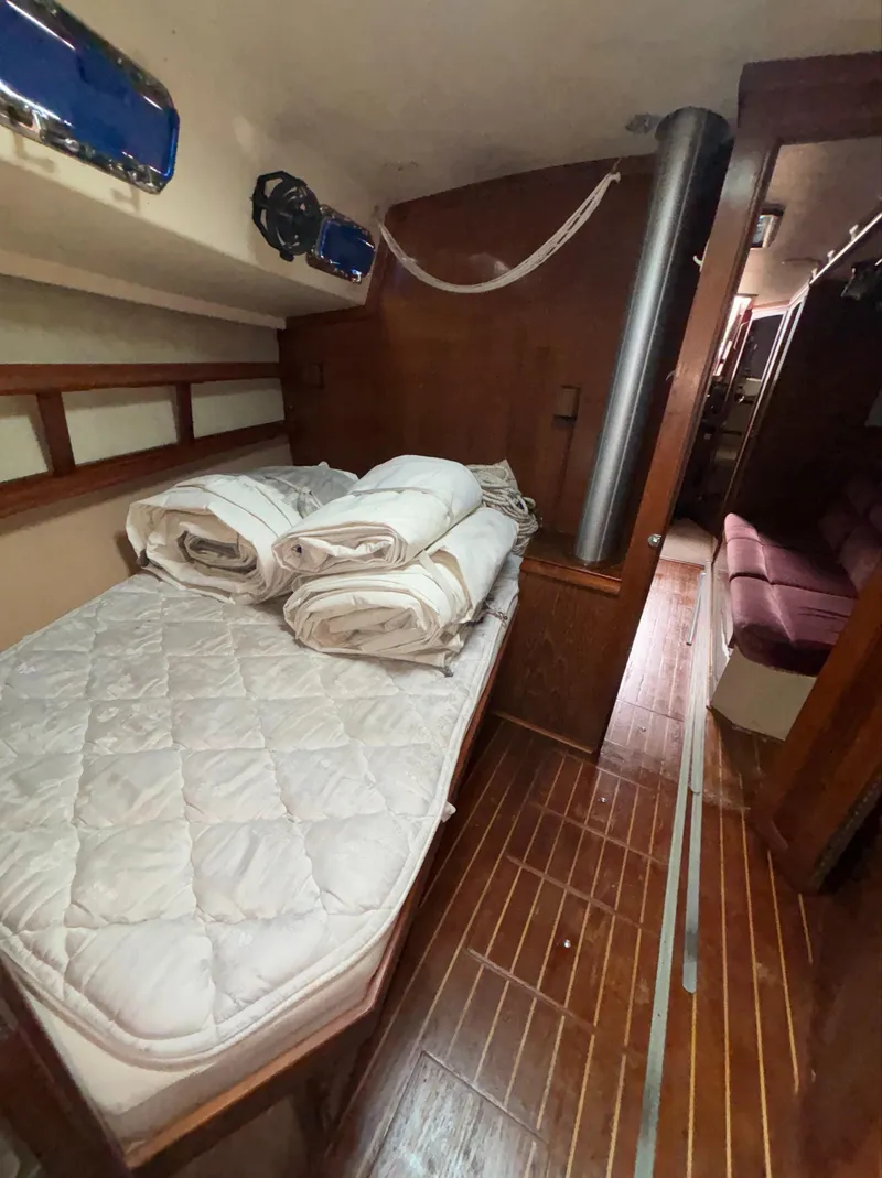 Slide: The Image of Cozy cabin interior of 1987 Island Packet 38 sailboat with bed and wooden flooring. - 14