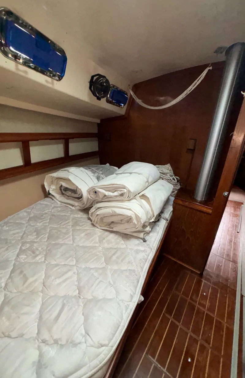Slide: The Image of Cozy cabin interior of 1987 Island Packet 38 sailboat with neatly arranged bedding. - 15