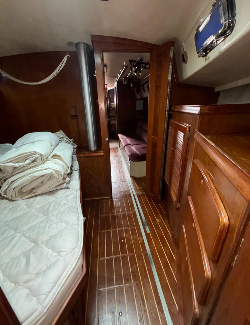 Slide: The Image of 1987 Island Packet 38 interior with wooden finish, cozy bed, and storage cabinets. - 16