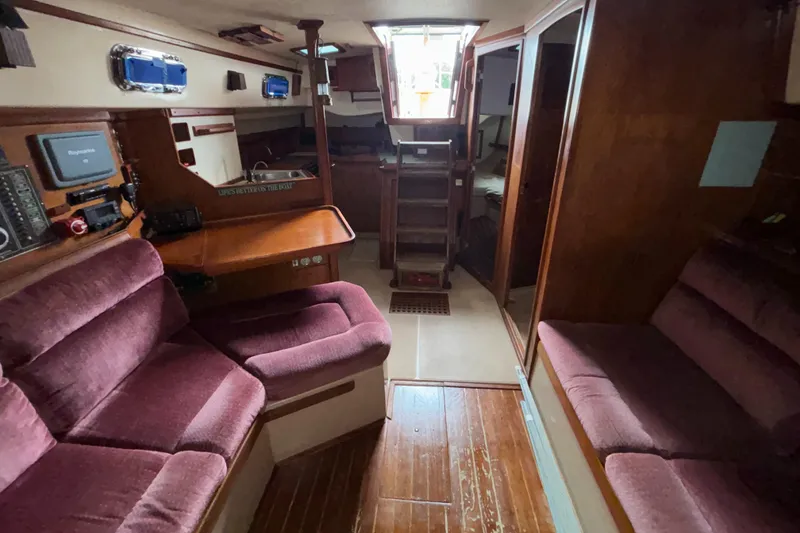 Slide: The Image of Interior of 1987 Island Packet 38 sailboat with plush seating and wooden finishes. - 18