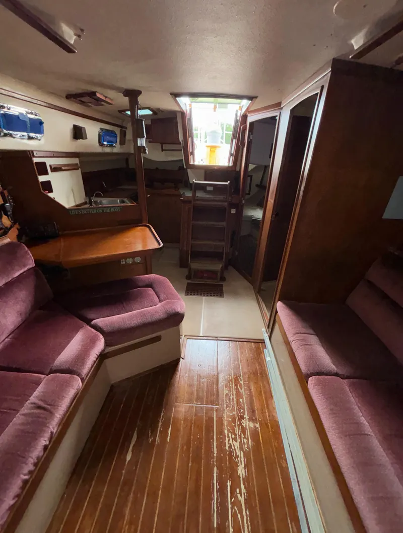 Slide: The Image of Interior of 1987 Island Packet 38 sailboat with wood flooring and plush seating. - 19