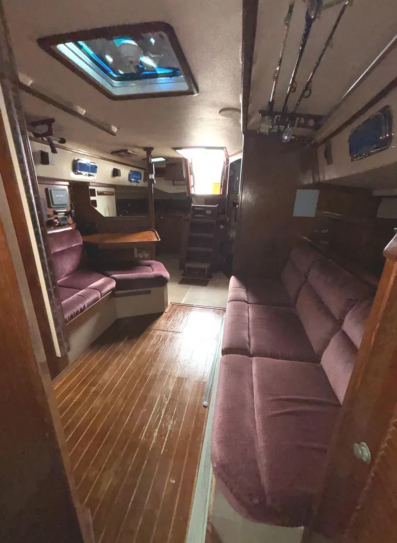 Slide: The Image of Interior of 1987 Island Packet 38 sailboat with plush seating and wooden flooring. - 20