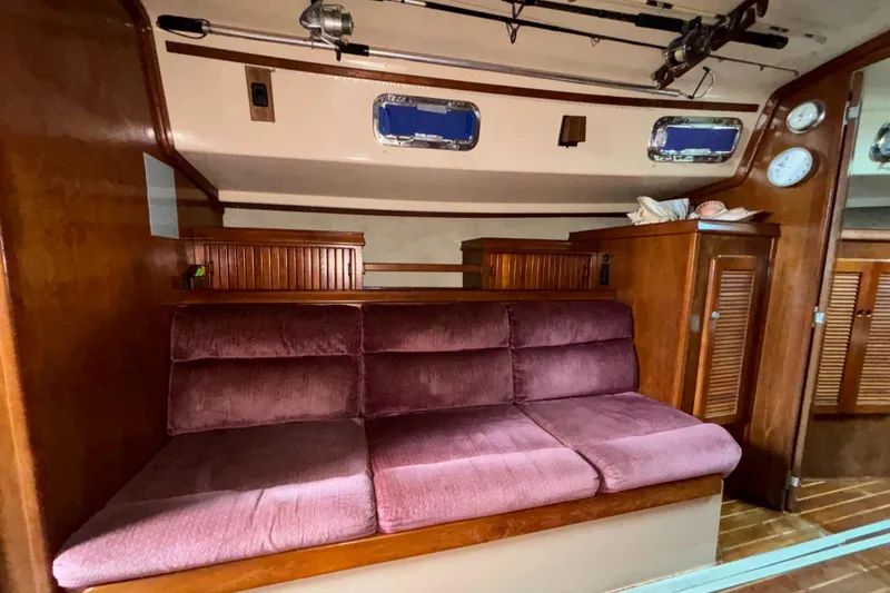 Slide: The Image of Interior of 1987 Island Packet 38 sailboat with plush seating and wooden cabinetry. - 21