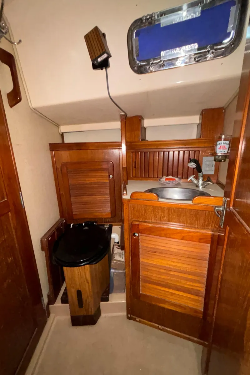 Slide: The Image of 1987 Island Packet 38 yacht interior with wooden cabinetry and compact sink area. - 26