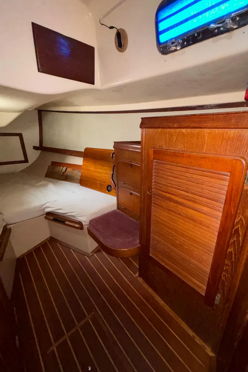 Slide: The Image of 1987 Island Packet 38 cabin interior with wooden furnishings and cozy sleeping area. - 27